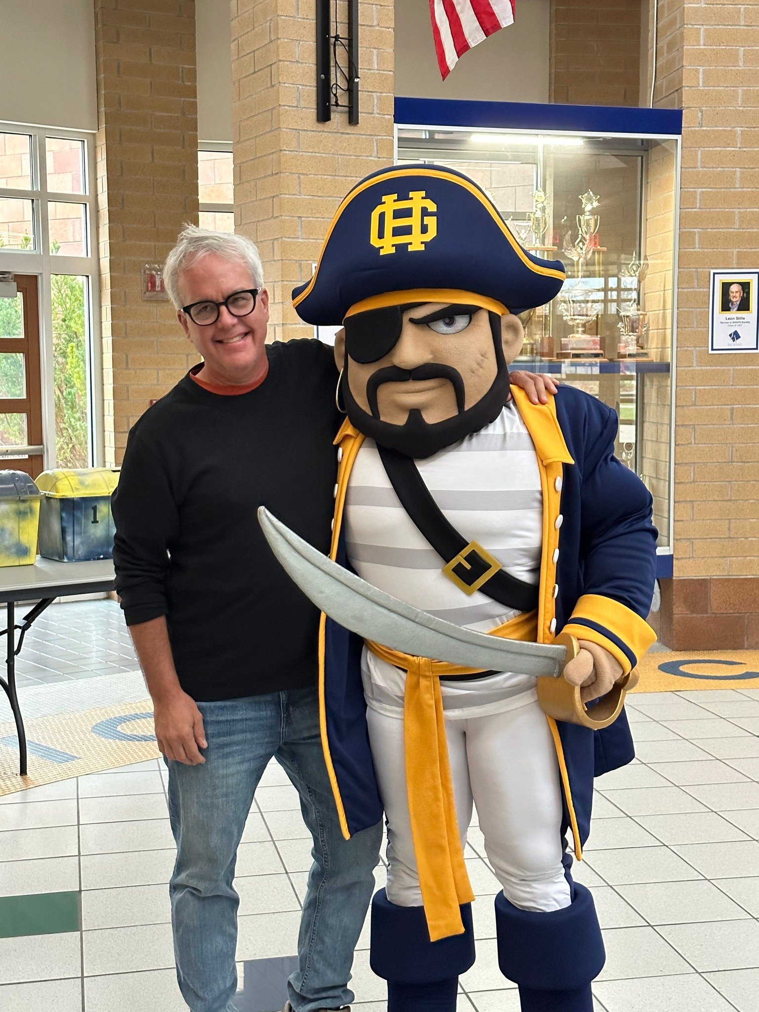 teacher pictured with grand haven mascot