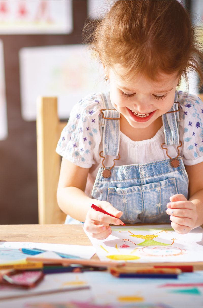 little girl coloring with colored pencils