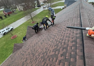 roofers standing on peak of new shingled roof