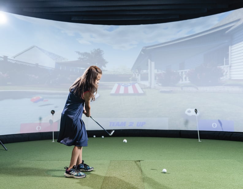 girl playing golf cornhole on simulator