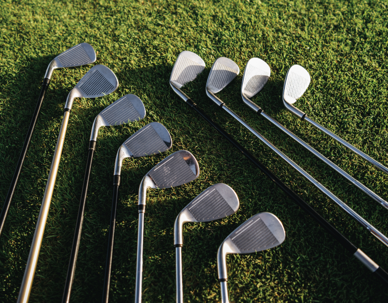 set of golf clubs laying in the grass